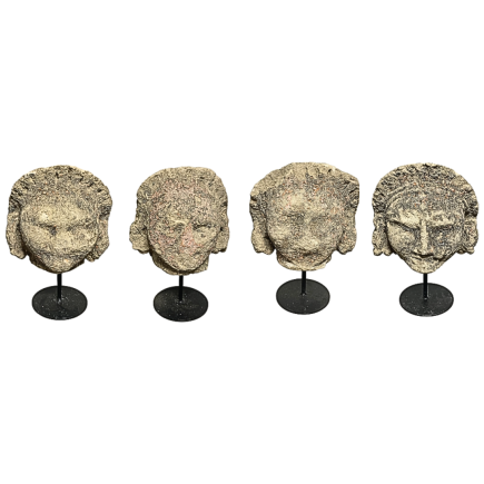 set-of-four-limestone-fragments-featuring-stylized-human-faces-suggest